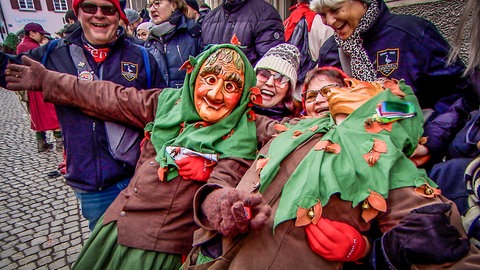 Deutsche Narren nutzen die amerikanischen Kollegen bei der Straßenfastnacht als Sitzgelegenheit