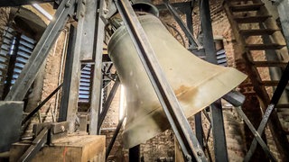 Riesenglocke im Glockenturm der Stadtkirche Giengen (Landkreis Heidenheim). Die teils tonnenschweren Glocken in der Giengener Stadtkirche sind mit hölzernen Gewichten gebremst worden.