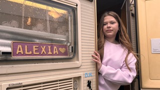 Alexia schaut aus ihrem "Jugendzimmer" raus - ihrem Campingwagen.