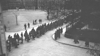 Eine Gruppe polnischer ziviler Zwangsarbeiter wird auf der Schaffnerstraße südlich des Charlottenplatzes vorbeigeführt (um 1940).