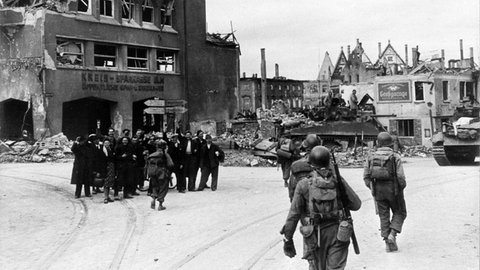 Die am 24.4.1945 in Ulm einrückenden amerikanischen Soldaten werden von Zwangsarbeitern als Befreier freudig begrüßt.