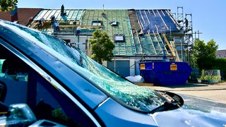 Die vom Tornado betroffenen Häuser in Ulm Gögglingen-Donaustetten sind noch mit Planen abgedeckt. Handwerker sind mit dem Wiederaufbau beschäftigt.