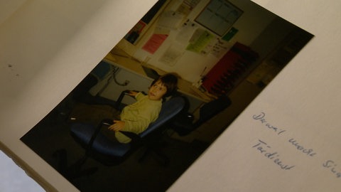 Ein altes Foto in einem Album zeigt ein kleines Mädchen an einem Schreibtisch. Daneben steht: "Derweil macht Sina Tischdienst". Sina Rastakhiz hat ihre Eltern schon als Kind zur Arbeit in die Klinik Heidenheim begleitet.