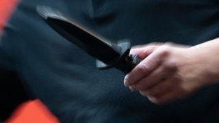 Ein Mann hält ein Messer in der Hand (Symbolbild)