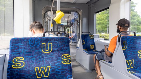 Zwei Fahrgäste in einer Ulmer Straßenbahn. Straßenbahnen und Busse der Stadtwerke Ulm (SWU) sollen laut ver.di am Montag und Dienstag bestreikt werden.
