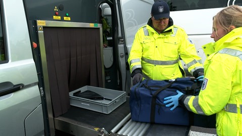 Wie bei der Sicherheitskontrolle am Flughafen wird bei der Kontrolle der Reisebusse das Gepäck der Reisenden durchleuchtet. Das mobile Röntgengerät ist in einem grauen Transporter eingebaut.