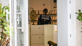 Eine Polizistin steht in einem Juweliergeschäft. Ein unbekannter Mann hat einen Juwelier in Aalen mit einer Schusswaffe überfallen.