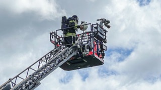 Die Feuerwehr bekämpft von einer Drehleiter aus den Brand eines Dachstuhls in einem Mehrfamilienhaus in Schwäbisch Gmünd im Ostalbkreis.