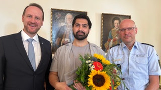 Der Schwäbsch Gmünder Kodyar Noori bekommt einen Blumenstrauß von Stadt und Polizei