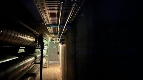 Die zwei dünnen Rohrleitungen des Transportsystems unter der Decke des Gangs führen unterirdisch vom Campus Nord zur Uniklinik - weil sie die Größe von Gartenschläuchen haben, ließen sie sich leicht neben anderen Leitungen verlegen.
