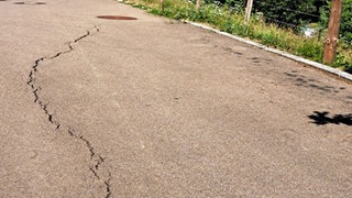 Bedrohliche Risse in der Straße am Rand eines Wohngebiets von Täferrot, die sich innerhalb kürzester Zeit auf bis zu vier Zentimeter Breite vergrößerten.