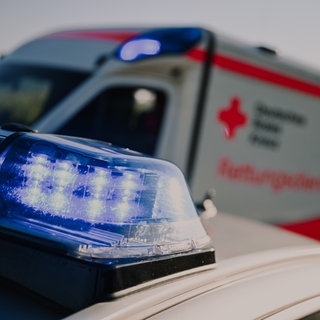 Blaulicht eines Polizeifahrzeugs, im Hintergrund ein Rettungswagen (Symbolbild)