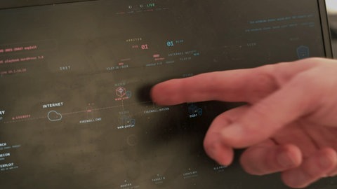 Cyberresilienzforum Ulm: Der Finger des Cybersicherheitsexperten weist auf ein Totenkopfsymbol hin: Der Hackerangriff zu Demonstrationszwecken zeigt offenbar Wirkung.
