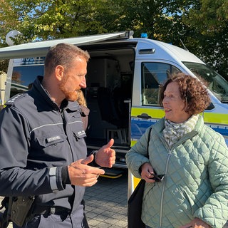 Einige Marktbesucher in Ulm-Wiblingen nehmen das Angebot an und informieren sich bei der Polizei, kommen ins Gespräch.