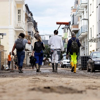 Nach dem Jahrhunderthochwasser im Ahrtal haben die Aufräumarbeiten Fortschritte gemacht. Viele Freiwillige helfen dabei, Straßen zu räumen und Schutt und Schlamm zu entfernen, wie hier in Bad Neuenahr.