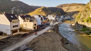Die Asphaltdecke der Ortsdurchfahrt der Bundesstraße 267 in Mayschoß wurde durch die Flut zerstört (Luftaufnahme mit einer Drohne). Das Hochwasser im Ahrtal hat auch das Straßennetz verwüstet. Nach notdürftigen Lösungen wollen Experten es nun winterfest machen. 