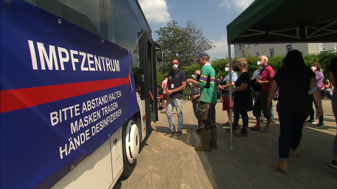 Menschen stehen vor dem Impfbus in der Schlange und warten auf ihre Impfung gegen das Coronavirus.