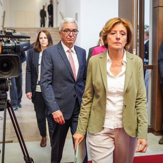 Der rheinland-pfälzische Innenminister Roger Lewentz (SPD, M) kommt gemeinsam mit der Ministerpräsidentin von Rheinland-Pfalz, Malu Dreyer (SPD, r), zu einer Pressekonferenz, bei der er seinen Rücktritt bekanntgab.