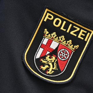 Das Logo der Polizei Rheinland-Pfalz auf einer Uniform (Symbolbild).