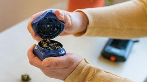 Eine Patientin öffnet einen Grinder, mithilfe dessen medizinisches Cannabis zerkleinert wurde.