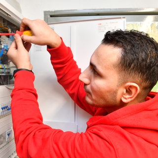 Syrer und Syrerinnen arbeiten als Elektriker (wie auf dem Foto) oder anderen Berufen mit Fachkräftemangel.