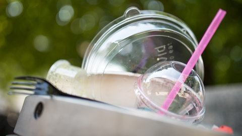 Plastikgeschirr liegt auf einem Mülleimer. Das Bundesverfassungsgericht hat die Verpackungssteuer in Tübingen für rechtmäßig erklärt. Welche Stadt in Rheinland-Pfalz zieht nach?