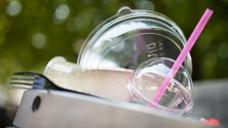Plastikgeschirr liegt auf einem Mülleimer. Das Bundesverfassungsgericht hat die Verpackungssteuer in Tübingen für rechtmäßig erklärt. Welche Stadt in Rheinland-Pfalz zieht nach?