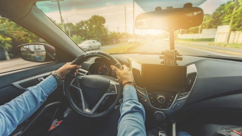 Fahrer hält Lenkrad bei hohem Tempo fest. Zu hohe Geschwindigkeit sind Unfallursache Nummer 1. 