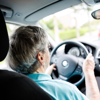 Eine über 90-jährige Frau sitzt hinter dem Lenkrad eines Autos. Ältere Menschen am Steuer eines Autos sind immer häufiger an Verkehrsunfällen beteiligt. (Symbolbild)