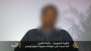 Ein Bild vom sitzenden Fahad A. vor einer weißen Wand wird im katarischen Sender Al-Jazeera gezeigt. Er sieht nicht direkt in die Kamera.