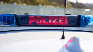 Leuchtende Polizei-Anzeige auf einem Polizeifahrzeug. Symbolbild für Polizeikontrolle