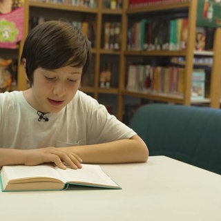 Der Schüler Bruno Kurz beim Lesen eines Buches