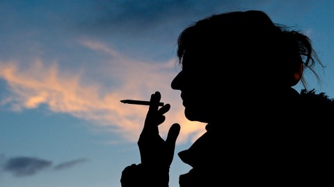Eine Frau raucht eine Zigarette. Bei Frauen ist Lungenkrebs auf dem Vormarsch, bei Männern wird er seltener.