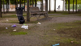 Mülle neben einer Parkbank in einem Park - oft werden Parks gewmieden, vor allem von Frauen