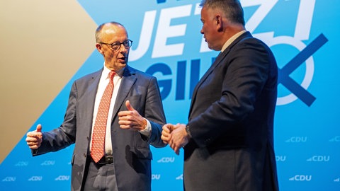 Bundeskanzler Merz (li) und CDU-Spitzenkandidat Gordon Schnieder beim Politischen Aschermittwoch in Trier. iOli