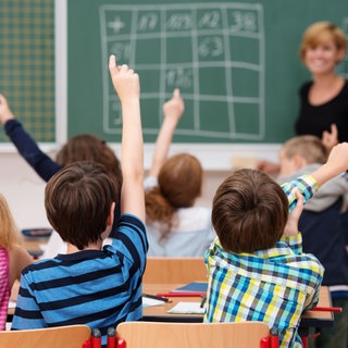Viele Schüler melden sich in einem Klassenraum 