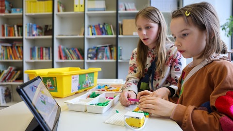 Zwei Grundschülerinnen vor einem Schul-Tablet