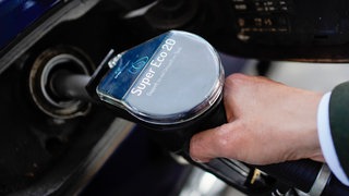 Eine Hand greift nach einem Zapfhahn mit der Aufschrift "Super Eco 20" - der neue Kraftstoff soll 2027 auch in RLP eingeführt werden. 