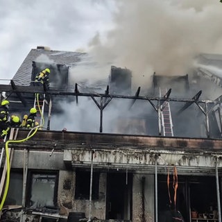 Feuerwehrkräfte sind am Löschen eines Hausbrandes