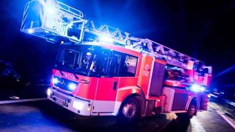 Ein Feuerwehrauto fährt mit Blaulicht zu einem Einsatz. Starker Regen hat im Rhein-Lahn-Kreis für zahlreiche Feuerwehreinsätze gesorgt (Symbolbild).