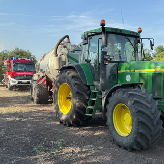 Ein Mitglied der Freiwilligen Feuerwehr und ein Landwirt im Gespräch
