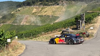 Ein Rennwagen fährt durch die Reben an der Mosel