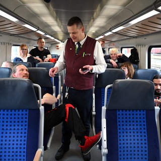 Ein Zugbegleiter wird beim Fahrkartenkontrollieren von einem Fahrgast behindert (Archivbild).