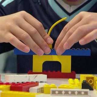 Ein Kind baut etwas mit Legosteinen