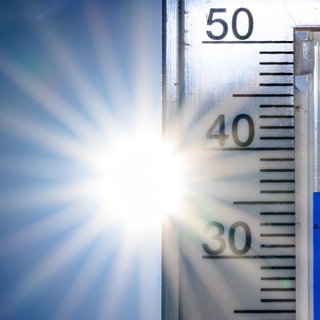Ein Thermometer zeigt 36 Grad an. Der DWD warnt vor großer Hitze in RLP (Archivbild).