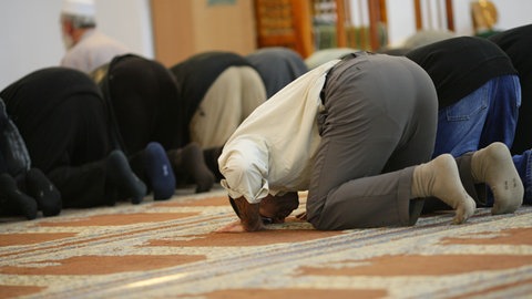 Gläubige beten im Gebetsraum einer Moschee. Am 3. Oktober ist Tag der offenen Moschee.