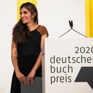 Die Gewinnerin des Deutschen Buchpreises 2026, Shida Bazyar aus Hermeskeil, steht auf der Bühne in Frankfurt.