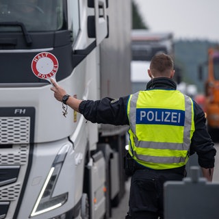 Polizisten kontrollieren Fahrzeuge auf der A64 bei Trier.