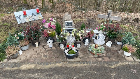 Viele Blumen und zahlreiche kleine Engelchen und Herzen stehen am Gedenkort für die beiden ermordeten Polizisten bei Kusel. 