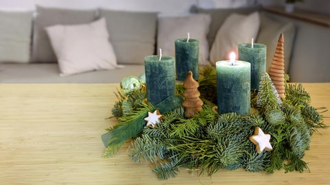 Auf einem Adventskranz brennt die erste Kerze zum 1. Advent. 